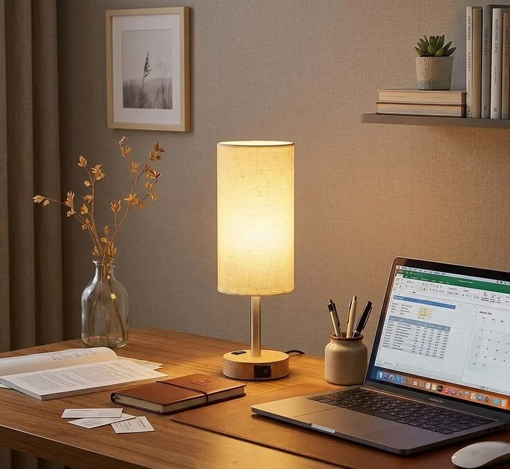A desk lamp and soft daylight from a side window falling across a clear work surface